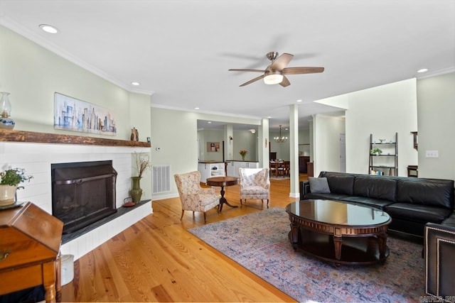 living room featuring hardwood / wood-style floors, ceiling fan, and ornamental molding