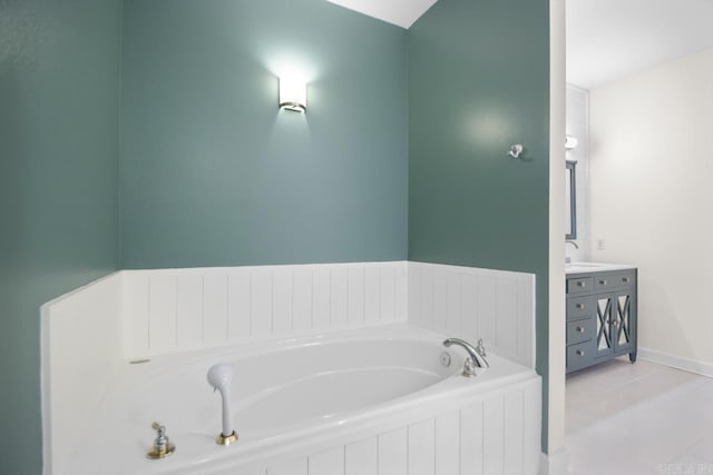 bathroom with tile patterned flooring, vanity, and a tub