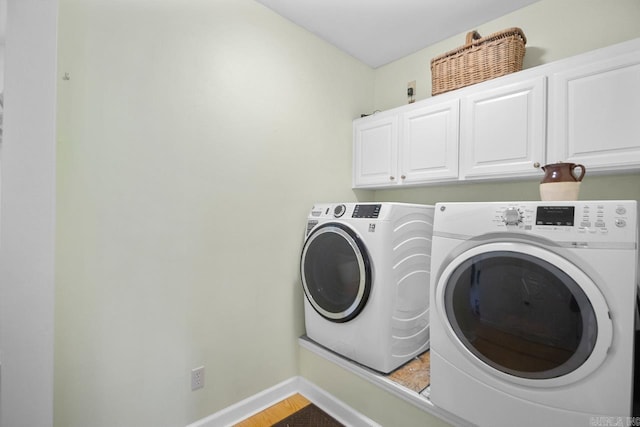 laundry area featuring separate washer and dryer and cabinets