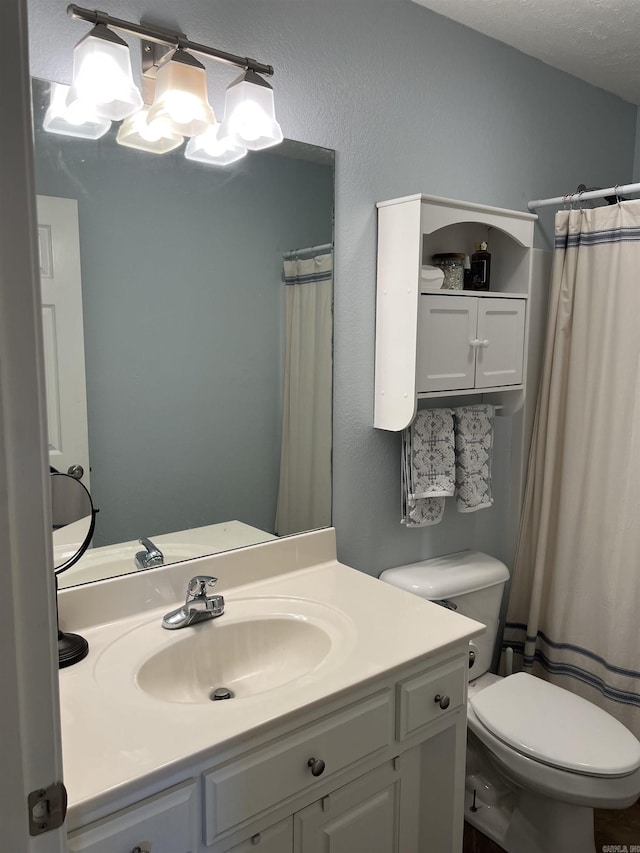 bathroom with vanity, a shower with shower curtain, a textured ceiling, and toilet