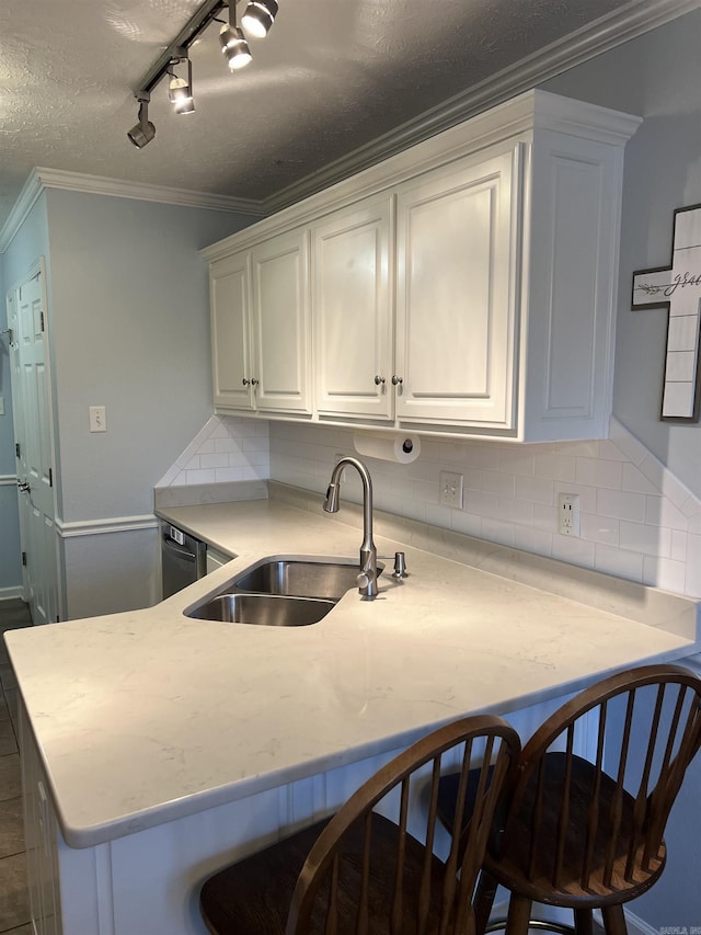 kitchen featuring backsplash, white cabinets, sink, crown molding, and kitchen peninsula