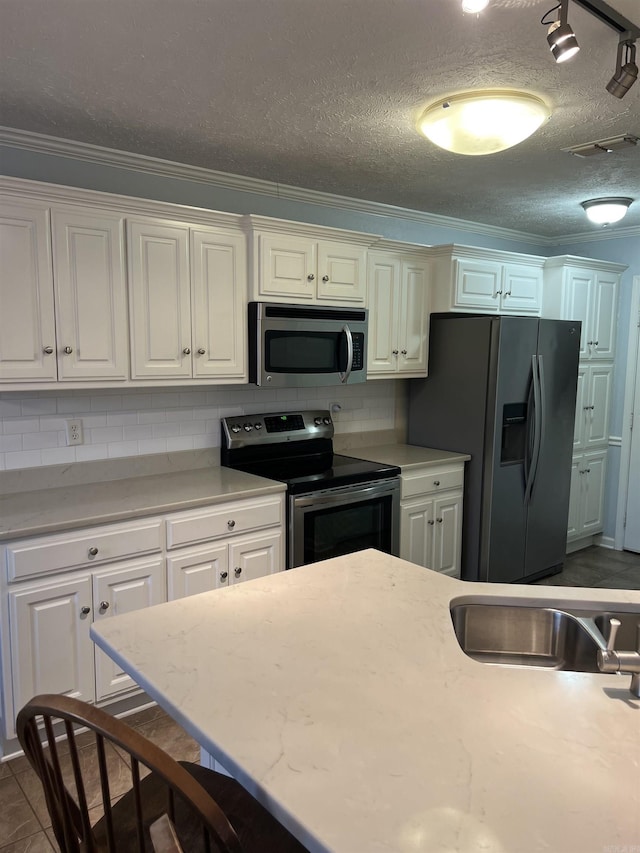 kitchen with white cabinets, appliances with stainless steel finishes, and a textured ceiling