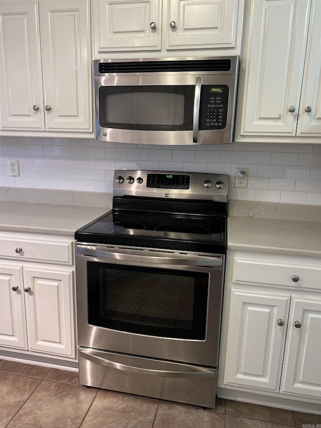 kitchen featuring white cabinetry, backsplash, and appliances with stainless steel finishes