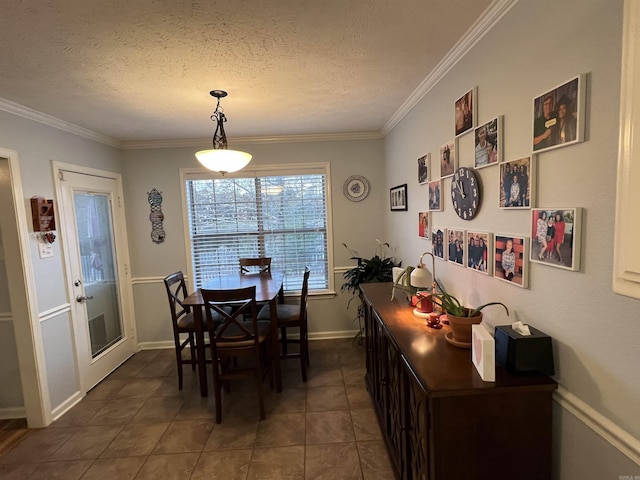 dining area featuring a textured ceiling, dark tile patterned flooring, and ornamental molding