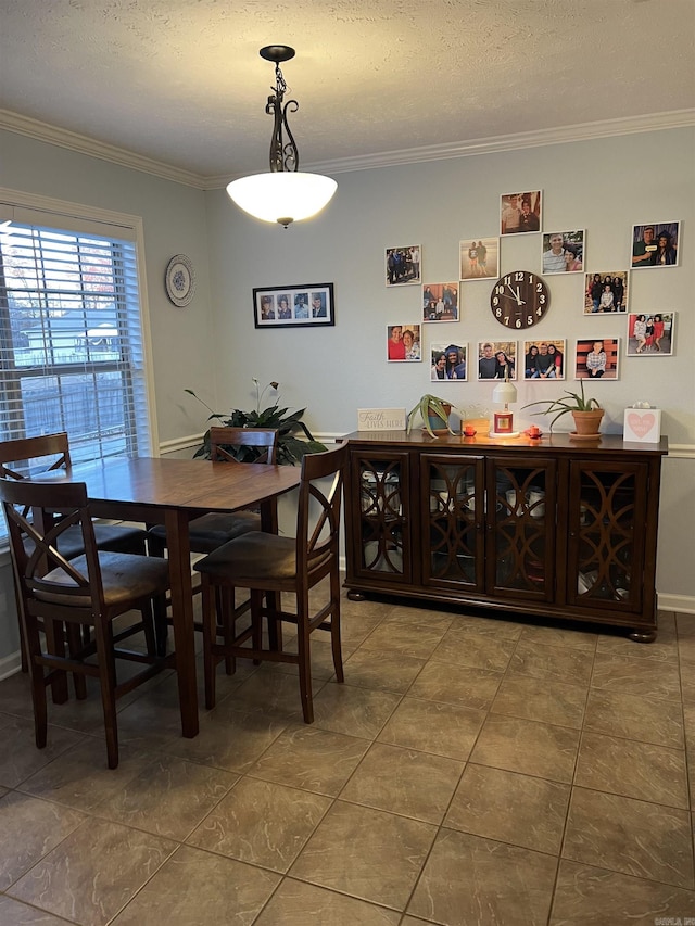 tiled dining space featuring a textured ceiling and ornamental molding