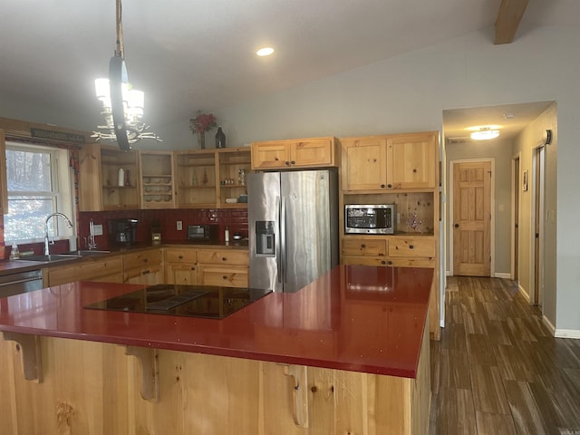 kitchen featuring appliances with stainless steel finishes, vaulted ceiling, dark wood-type flooring, decorative light fixtures, and a notable chandelier