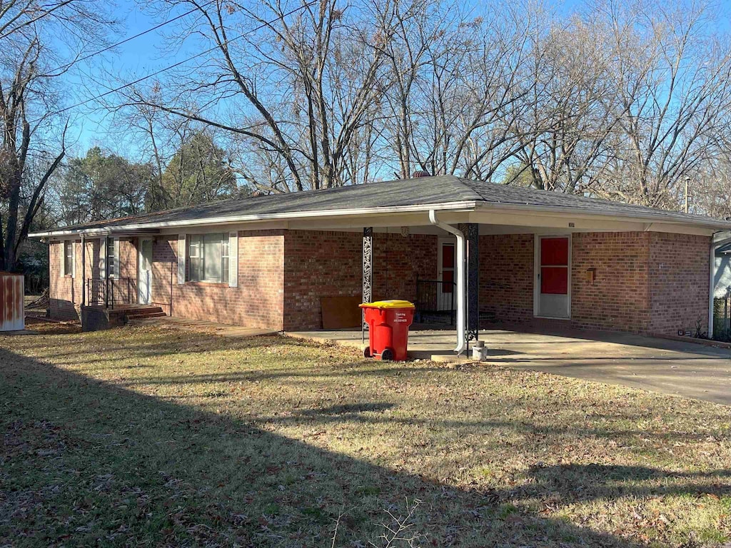 ranch-style house with a front yard and a carport