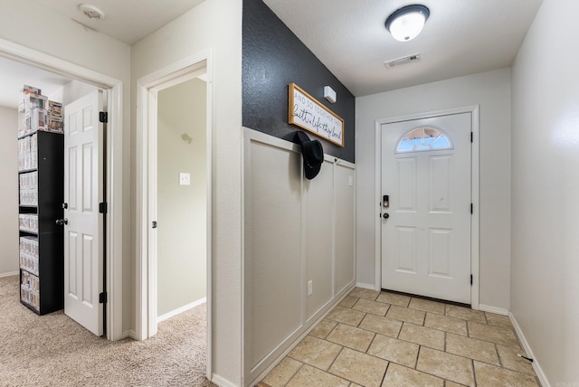 view of carpeted foyer entrance