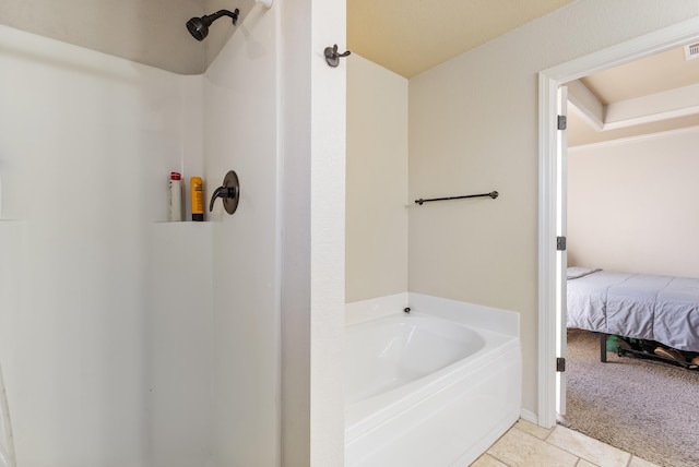 bathroom with tile patterned flooring and a tub