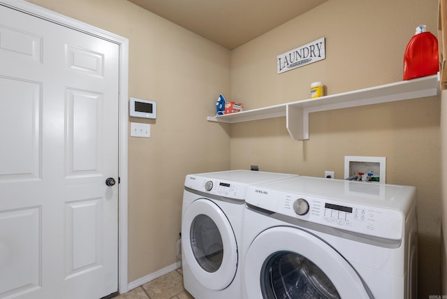 laundry room featuring washing machine and dryer and light tile patterned floors