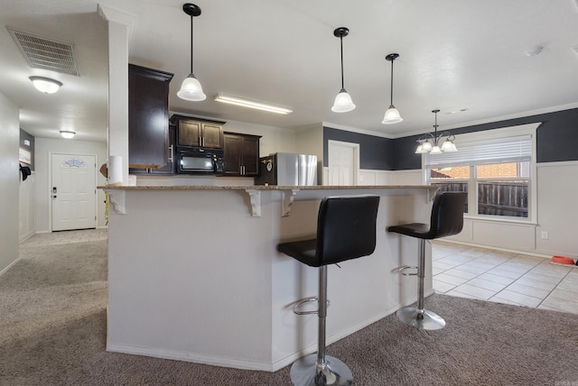 kitchen featuring dark brown cabinetry, stainless steel fridge, crown molding, a breakfast bar area, and light carpet