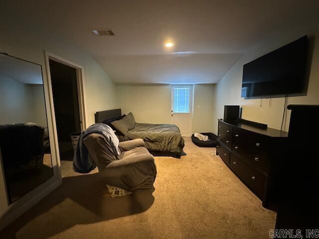 carpeted bedroom with lofted ceiling