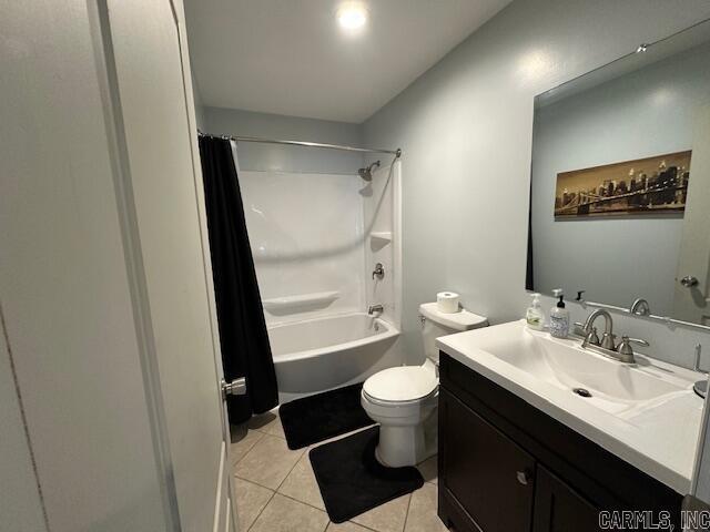 full bathroom featuring tile patterned flooring, shower / bath combination with curtain, vanity, and toilet