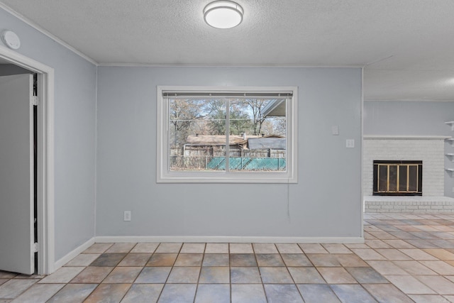 unfurnished dining area featuring ornamental molding, light tile patterned floors, a textured ceiling, and a brick fireplace