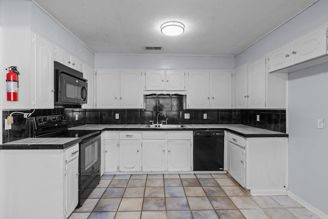 kitchen with sink, tile countertops, decorative backsplash, white cabinets, and black appliances