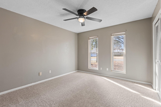 spare room with carpet flooring, ceiling fan, and a textured ceiling