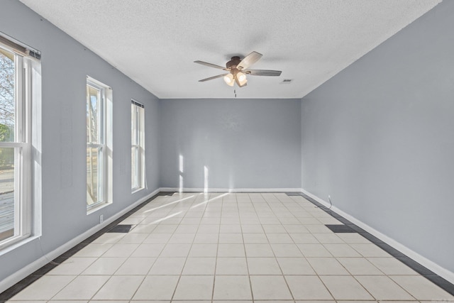 unfurnished room with ceiling fan, light tile patterned flooring, and a textured ceiling