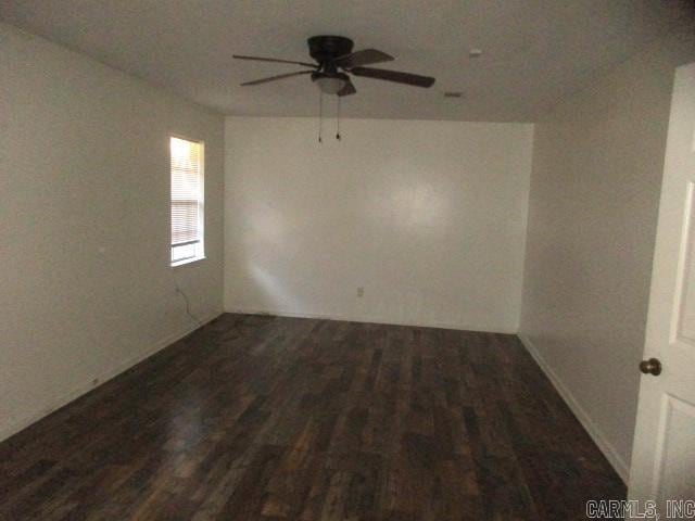 unfurnished room with ceiling fan and dark wood-type flooring