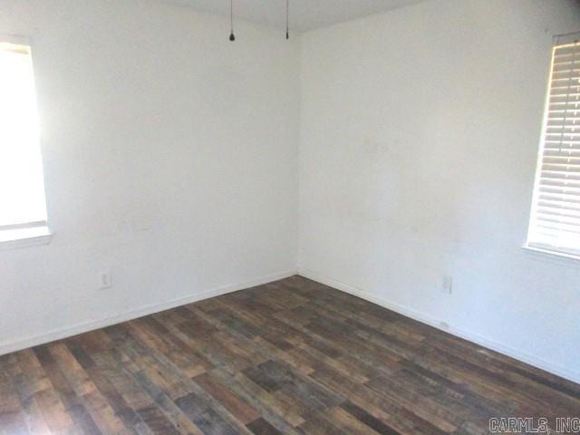 unfurnished room with dark wood-type flooring