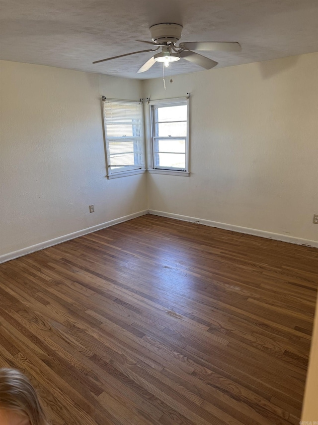 spare room featuring dark hardwood / wood-style floors and ceiling fan