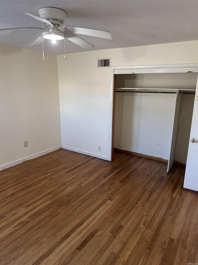 unfurnished bedroom featuring ceiling fan, a closet, and dark hardwood / wood-style floors