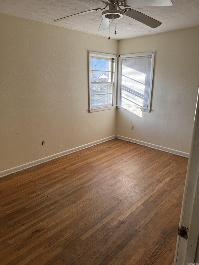 unfurnished room with dark hardwood / wood-style flooring and ceiling fan