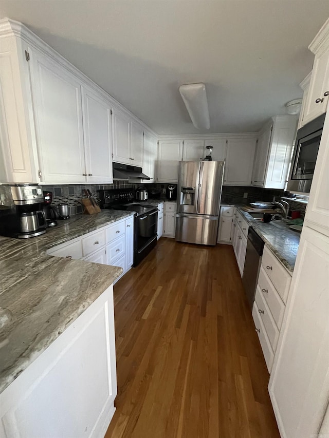 kitchen with tasteful backsplash, white cabinetry, dark wood-type flooring, and stainless steel appliances