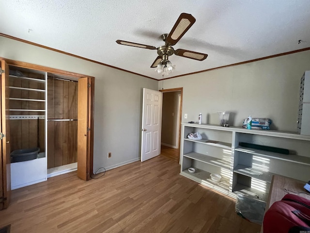 bedroom with a textured ceiling, hardwood / wood-style flooring, ceiling fan, and ornamental molding