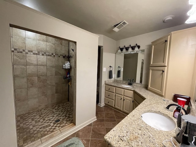 bathroom with tile patterned floors, vanity, and tiled shower