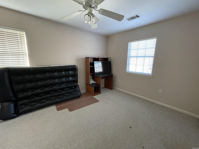 living area featuring light carpet and ceiling fan