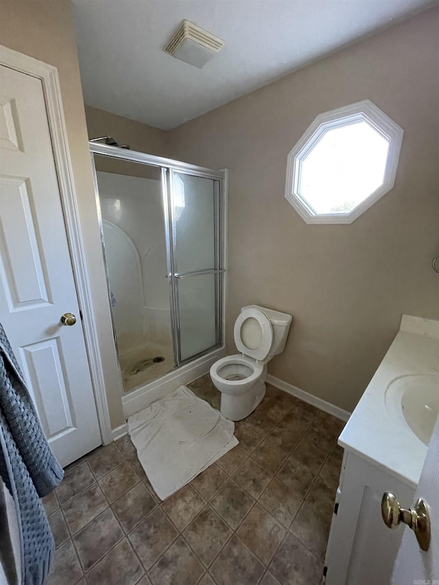 bathroom featuring tile patterned flooring, vanity, toilet, and an enclosed shower