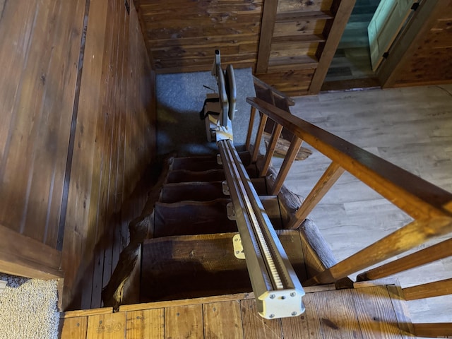 staircase with hardwood / wood-style flooring and wooden walls