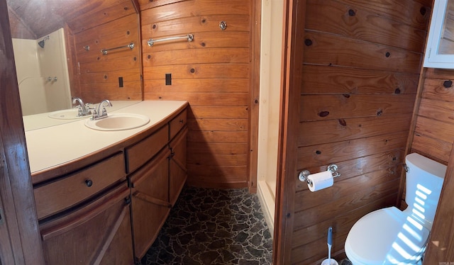 bathroom featuring wooden walls, vanity, and toilet