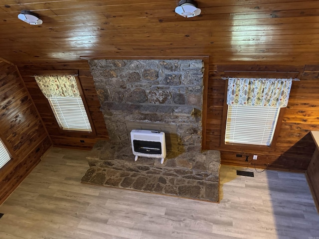 details with heating unit, wood walls, and hardwood / wood-style flooring