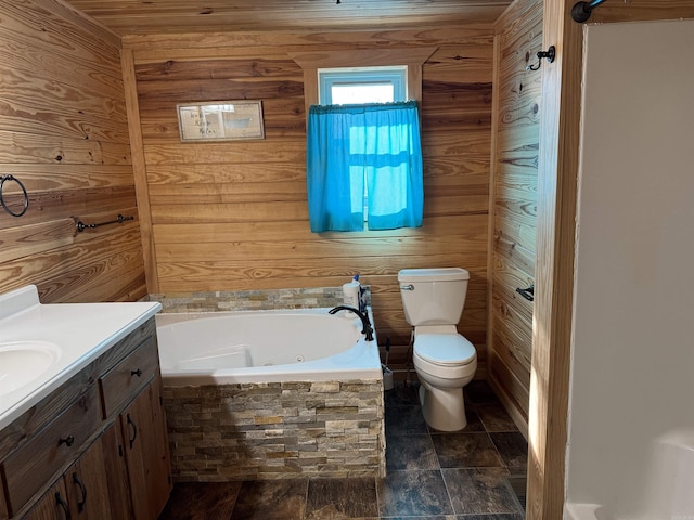 bathroom with vanity, toilet, a tub, and wooden walls