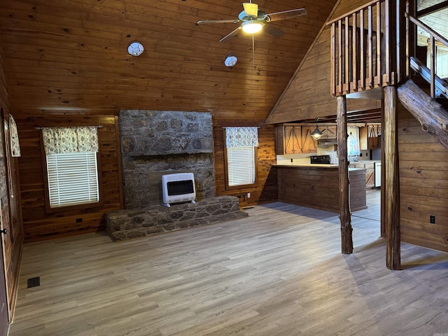 unfurnished living room with wood walls, light hardwood / wood-style floors, a healthy amount of sunlight, and wooden ceiling