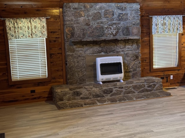 interior details with wood-type flooring, wooden walls, and heating unit