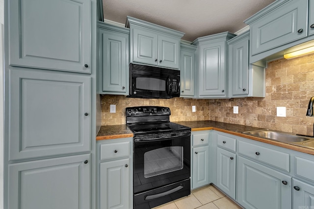 kitchen featuring black appliances, sink, light tile patterned floors, a textured ceiling, and tasteful backsplash