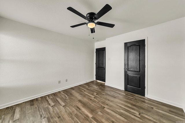 unfurnished bedroom with ceiling fan and dark wood-type flooring