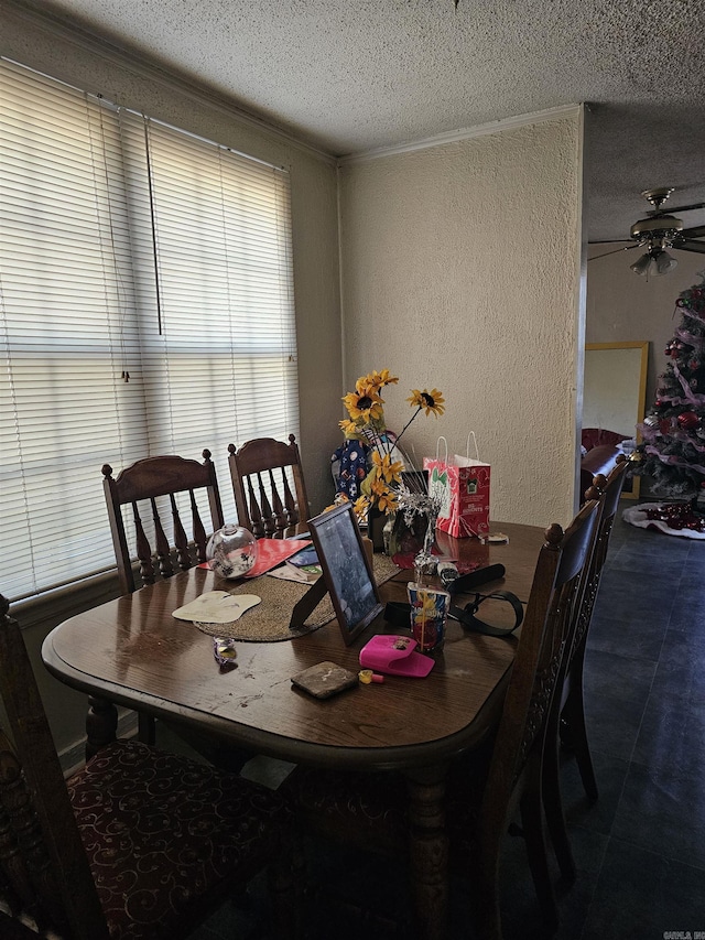 dining area featuring tile patterned flooring, a textured ceiling, ceiling fan, and ornamental molding