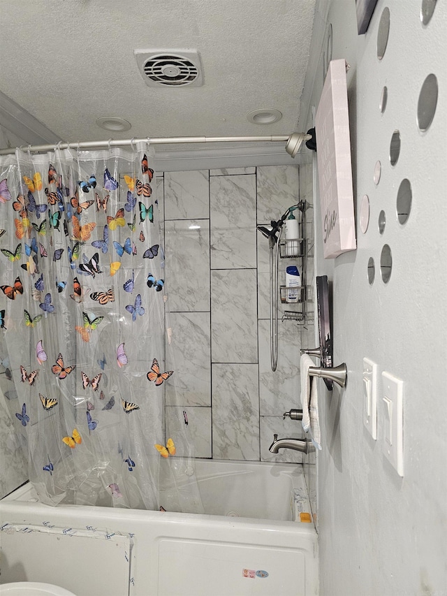 bathroom featuring a textured ceiling and shower / bathtub combination with curtain