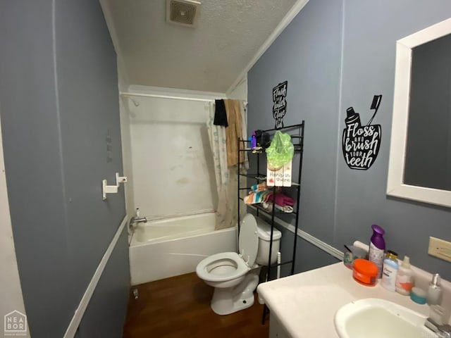 full bathroom featuring shower / bathtub combination, ornamental molding, a textured ceiling, wood-type flooring, and toilet