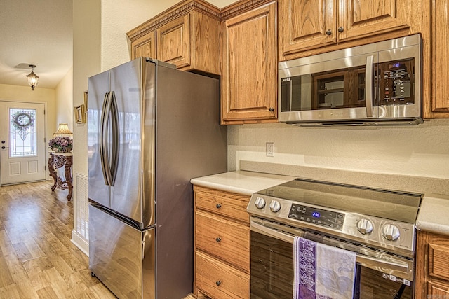 kitchen featuring stainless steel appliances and light hardwood / wood-style flooring