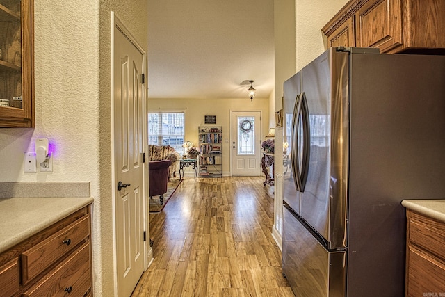 kitchen featuring stainless steel fridge and light hardwood / wood-style flooring