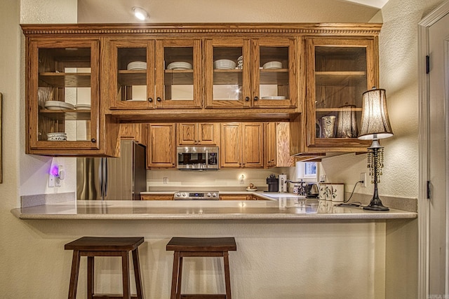 kitchen with sink, stainless steel appliances, and a breakfast bar area