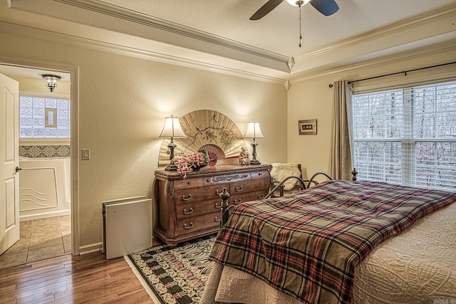 bedroom with ceiling fan, wood-type flooring, and ornamental molding