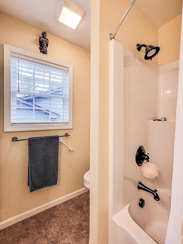 bathroom featuring tile patterned floors, toilet, and bathing tub / shower combination