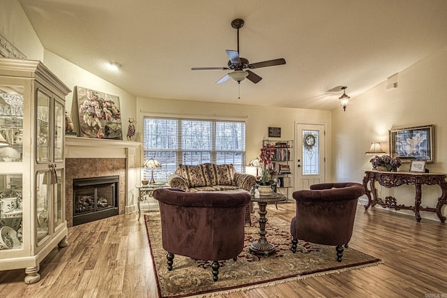 living room with ceiling fan, wood-type flooring, and lofted ceiling