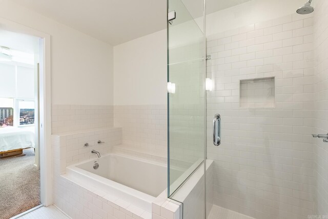 bathroom featuring separate shower and tub