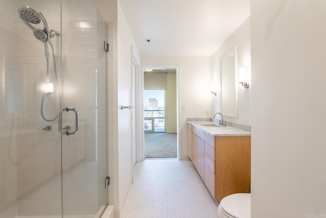 bathroom with toilet, vanity, tile patterned floors, and a shower with shower door